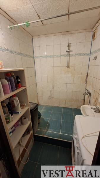 Bathroom in a 3-room apartment with a tiled floor and a washing machine.