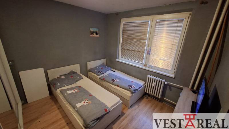 A children's room with two beds and a wooden decor floor in a 3-room apartment.