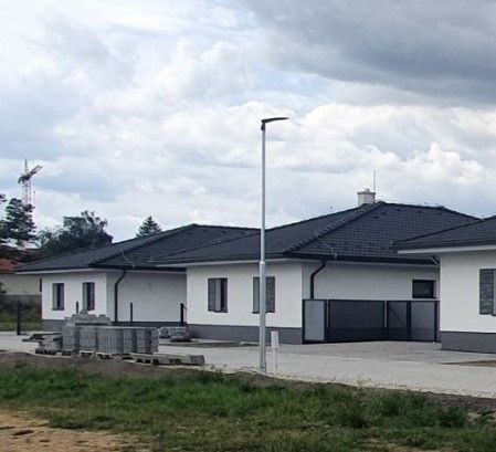 A family house on Leknová Street in Láb with a modern roof and a repaired sidewalk.