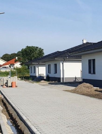 Family houses on Leknová Street in Láb with a paved road and gardens.