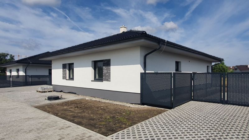 A family house on Leknová Street in Láb with a modern fence and a paved driveway.