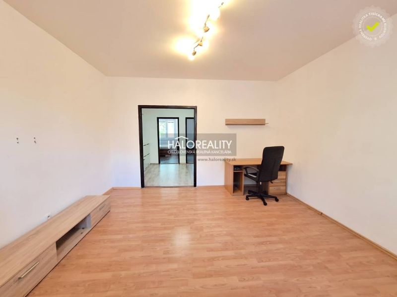 A room in a 4-room apartment with a wooden decor floor and a work desk.
