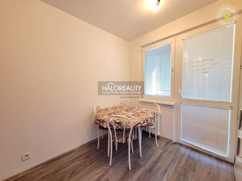 Dining area with a table, chairs, and flooring with a wooden decor in a 4-room apartment.