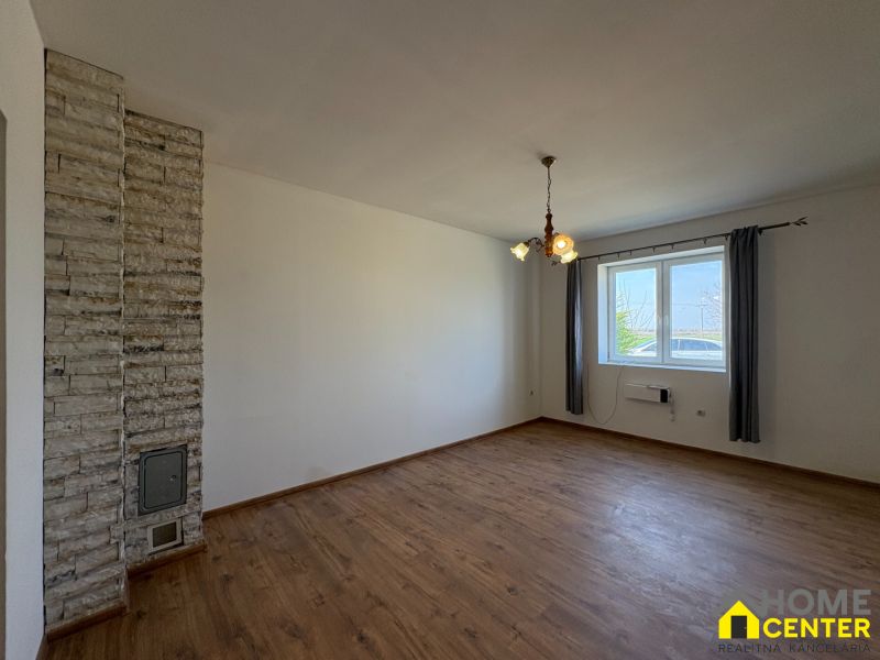 Interior of a family house with a wooden decor floor and a stone wall.