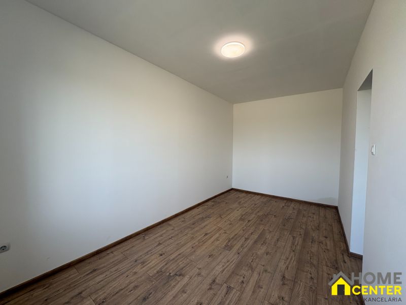 A room with white walls and a wooden decor floor in a family house.