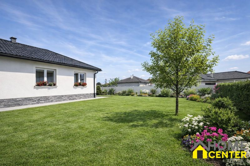 A family house in Zemianska Olča with a well-maintained garden and a flower bed.