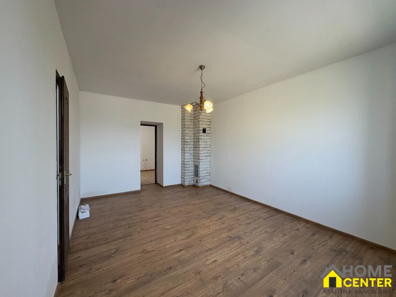 A room in a family house with a wooden decor floor and a brick wall.