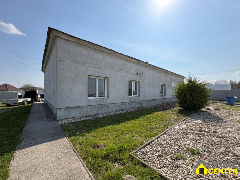A family house in Zemianska Olča, surroundings with greenery and a gravel path.