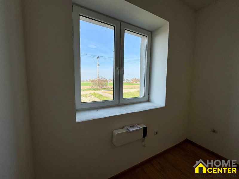 A room with a white window, a view of the garden, a floor with a wooden decor, a family house.