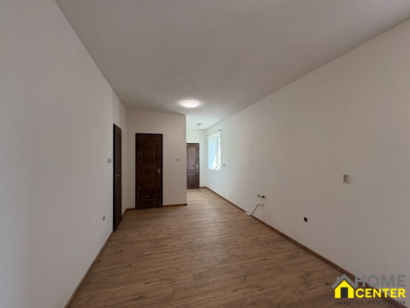 The interior of a family house with white walls and a floor with a wooden decor.