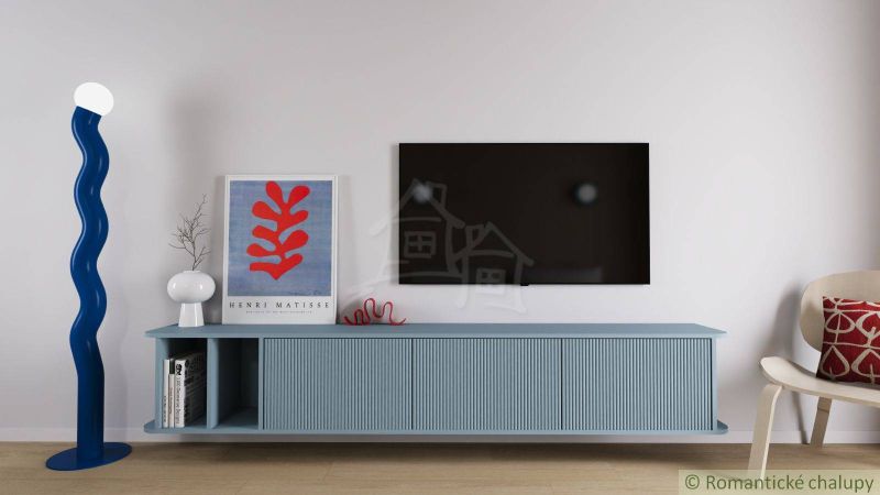 A living room in a cottage with minimalist furniture, a television, and a blue floor lamp.