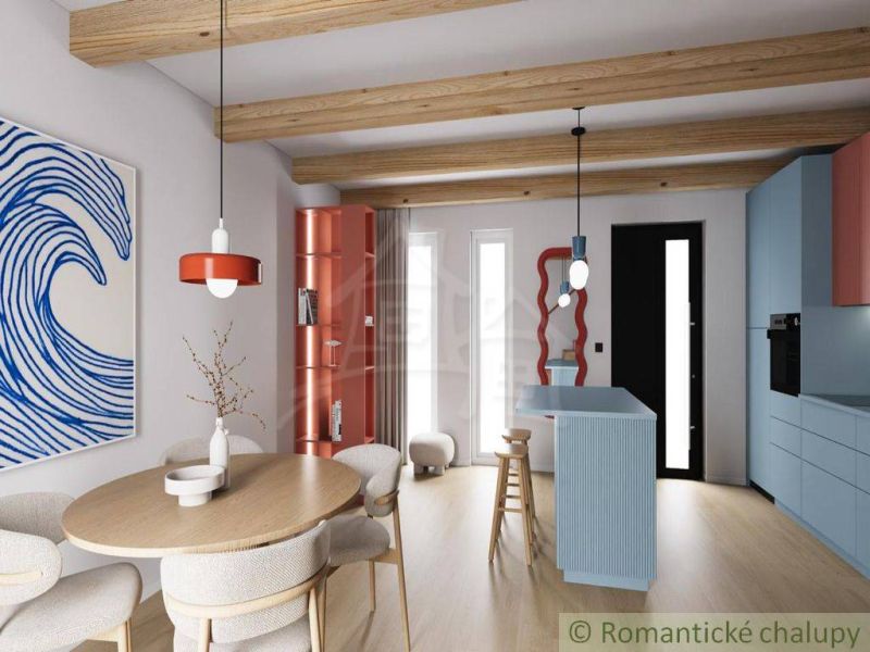 A cottage with a wooden decor floor and a colorful open kitchen, wooden beams.