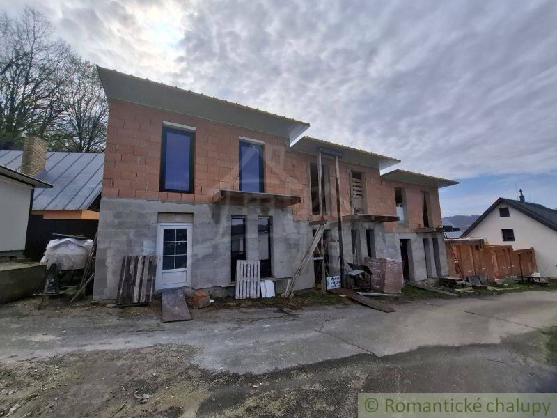 Unfinished cottage in Divín with a raw facade and glazed windows.