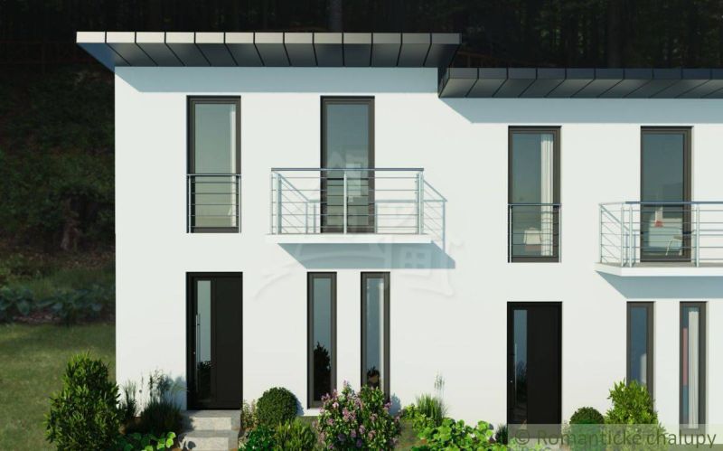 A two-story cottage in Divín with large windows and a balcony, surrounded by greenery.