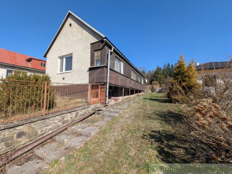 A family house in Kalinovo with concrete stairs and wooden railing on a slope.