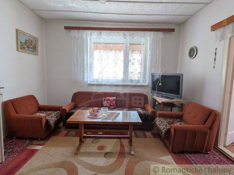 Living room in a family house with a brown sofa and a television.