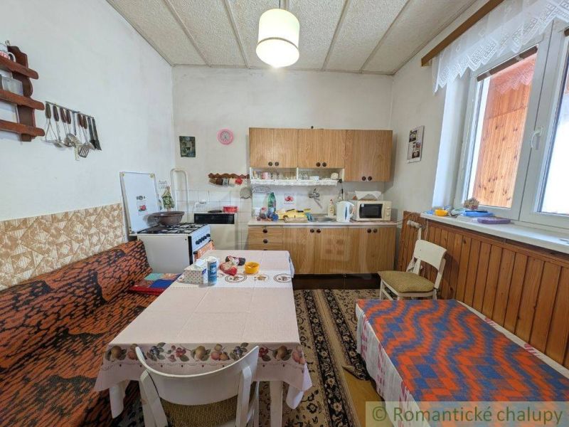 A kitchen in a family house with wooden decor and furniture, comfortable seating at the table.