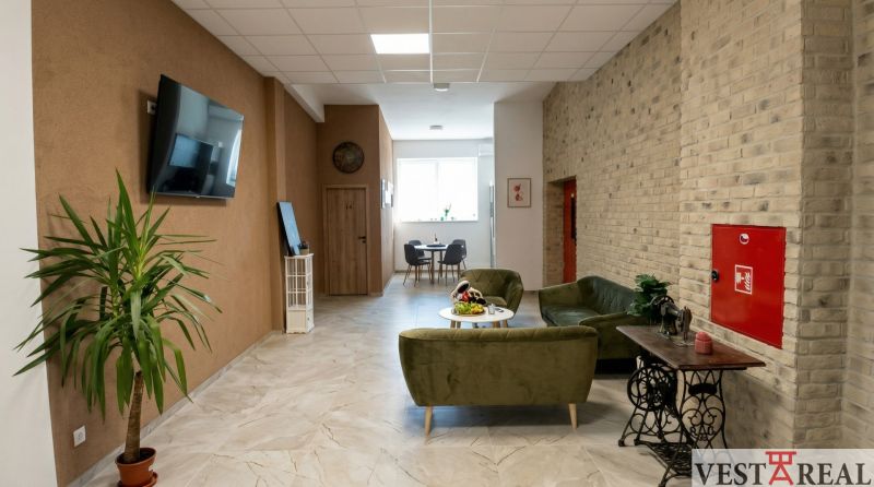 Offices with comfortable seating, a plant, and a television, floor with wood decor.