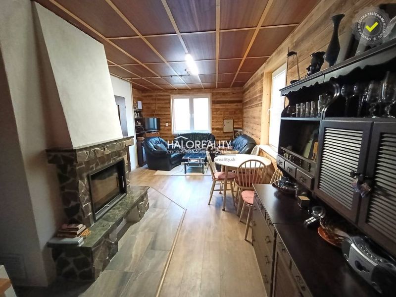 The interior of a cabin with a fireplace, wooden floor decor, and cozy furniture.