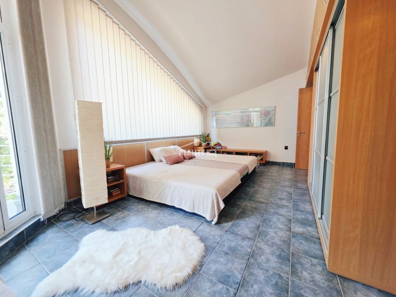 Recreational apartment with a bed, blue floor, light wall, and decorative carpet.