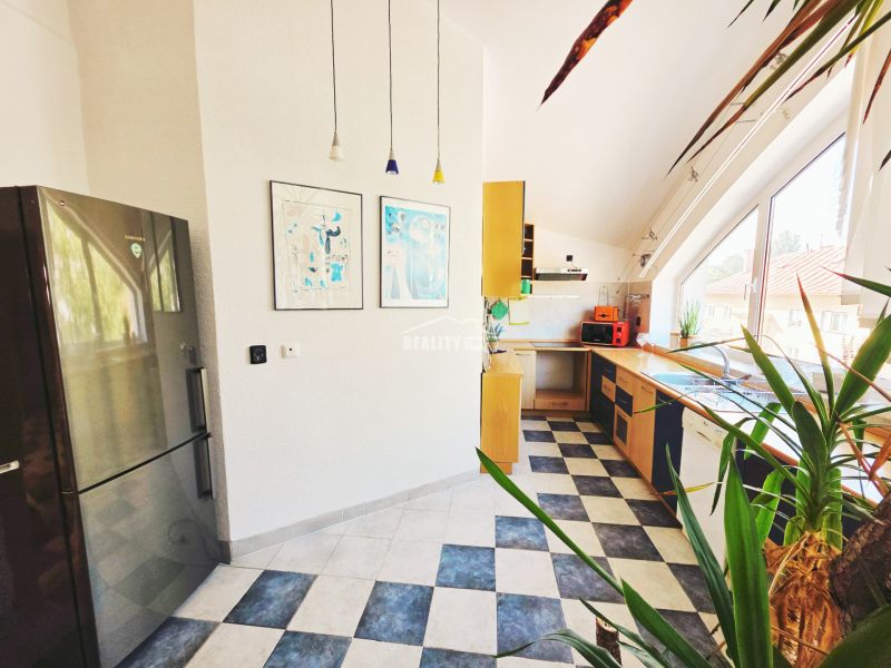 A kitchen in a holiday apartment with colorful accessories and a large window.
