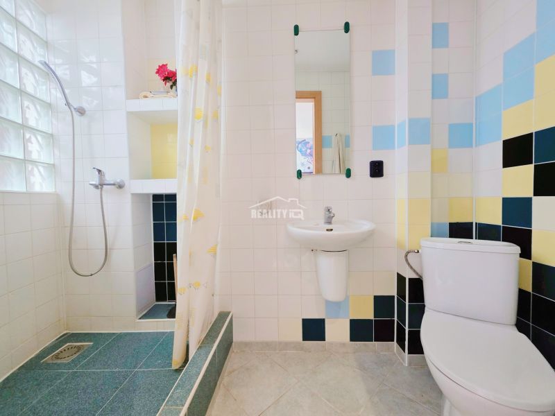 Bathroom with colorful tiles in the Holiday Apartment.