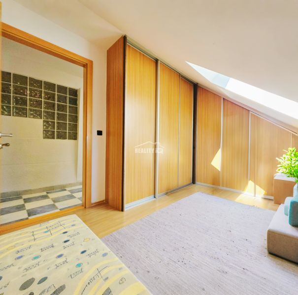 A hallway in a 5 or more room apartment with a wooden decor floor and built-in wardrobes.