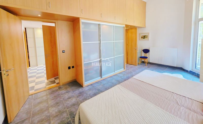 Bedroom in a vacation apartment with a sliding wardrobe and large windows.