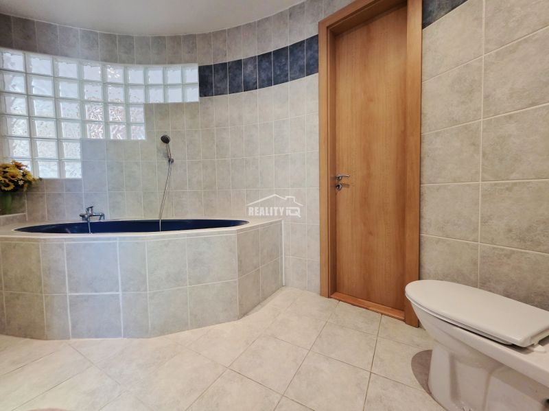 Bathroom with an oval bathtub, shower, and tiles in the Holiday Apartment.