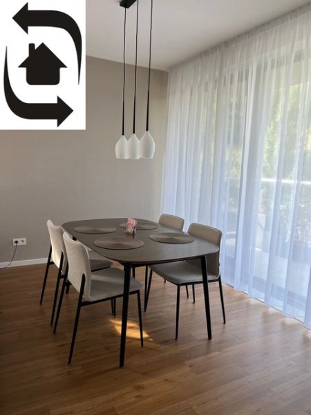 Dining table with chairs, curtains, wooden decor flooring in a 2-room apartment.