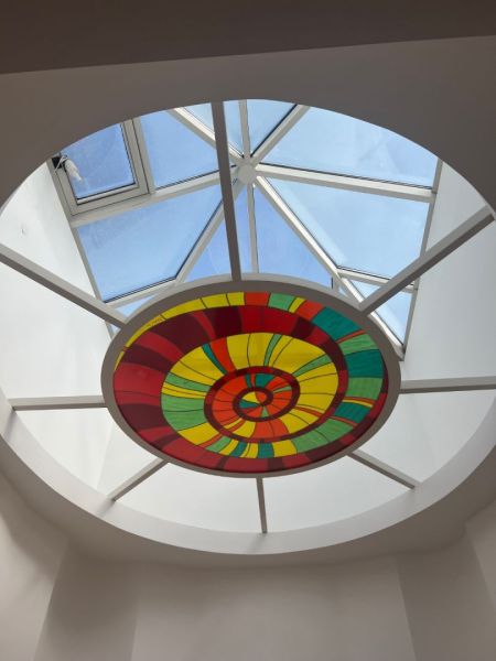 A glass dome with a colorful stained glass design illuminates the space on Štefánikova Street and the offices.