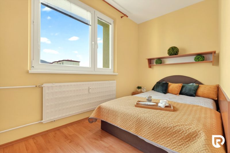 A bedroom with a bed and decorations, a 3-room apartment, floor with wooden decor.