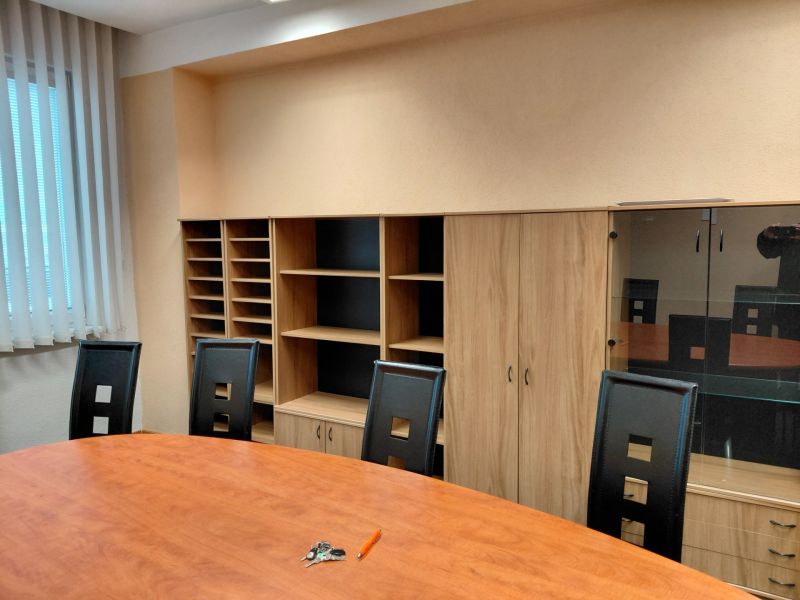 Office with a conference table, office chairs, and furniture with a wood decor.