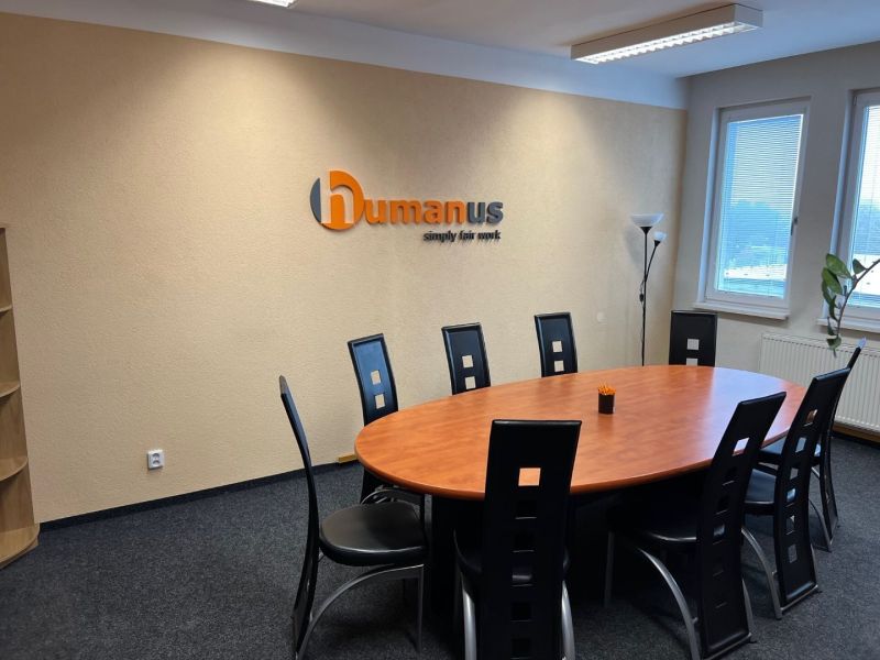Meeting room with an oval table and black chairs in the office.