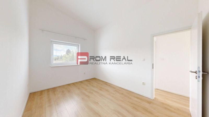 A room with white walls and a wooden decor floor in a 3-room apartment.