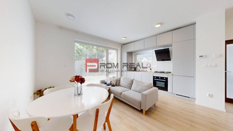 Living room with a kitchen and dining table in a three-room apartment, floor with wooden decor.