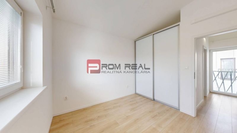 A room in a 3-room apartment with a wooden decor floor and a built-in wardrobe.