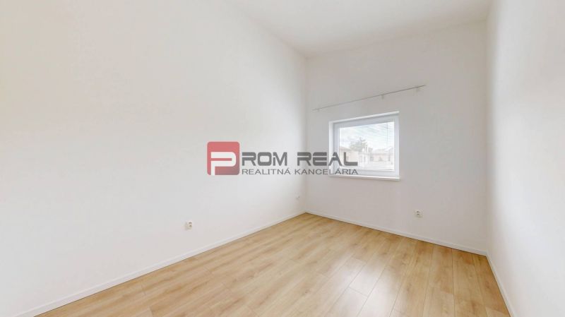 A bright room in a 3-room apartment with a wooden decor floor and a window.