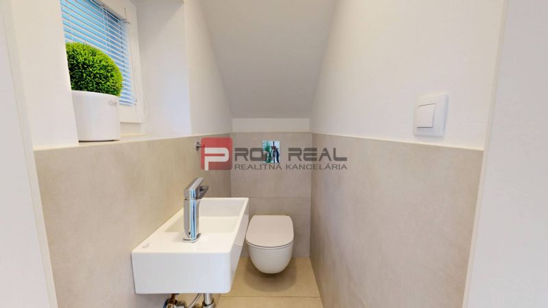 A toilet with a wall-hung WC and a washbasin in a 3-room apartment with a minimalist design.