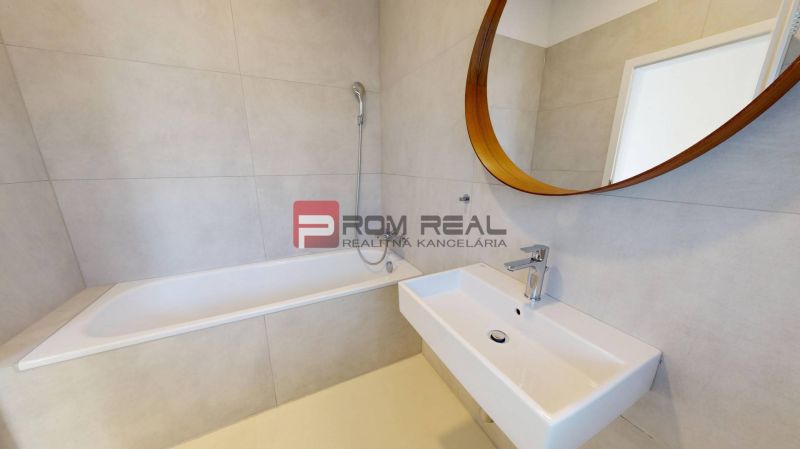 A bathroom with a mirror, bathtub, and sink in a 3-room apartment.