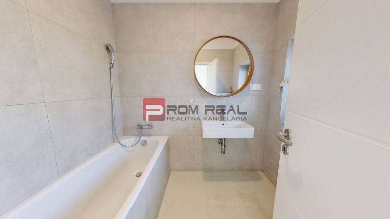 Bathroom in a 3-room apartment with a shower and a sink, large mirror on the wall.