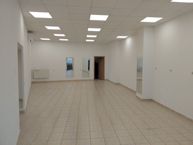 Commercial spaces with tiles, white walls, and ceiling lights.