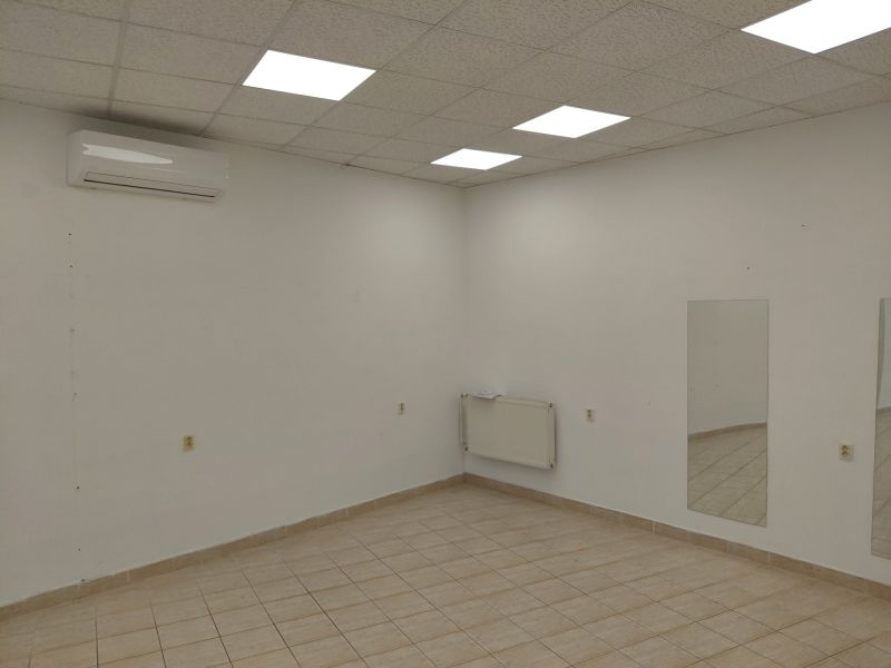 Commercial spaces with tiles, air conditioning, mirrors, and white walls.