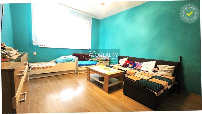 A children's room with colorful walls, a wooden decor floor, and comfortable furniture in a 3-room apartment.