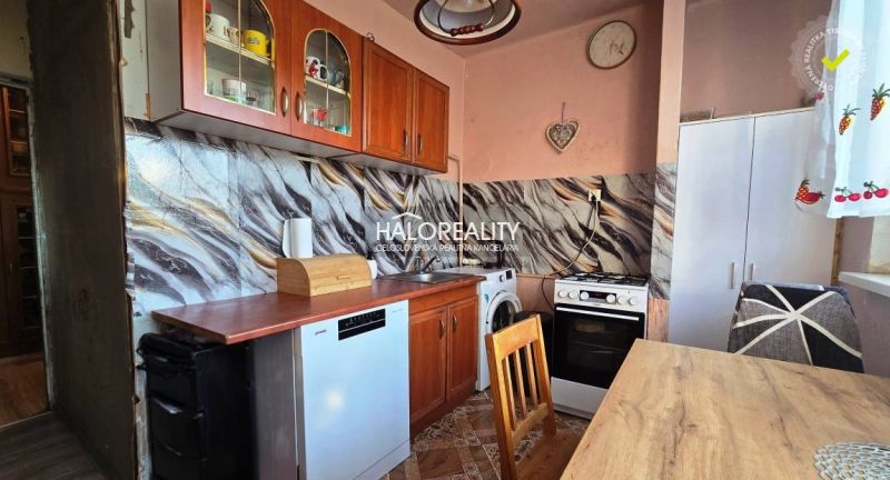 A kitchen in a 3-room apartment with wooden cabinets and appliances, flooring with a wooden decor.