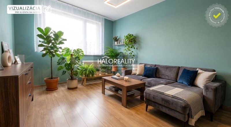 Living room in a 3-room apartment with a wooden decor floor, plants, and a sofa.