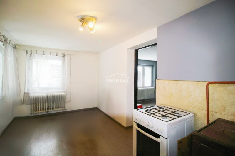 A kitchen in a family house with a gas stove and a floor with a wooden decor.