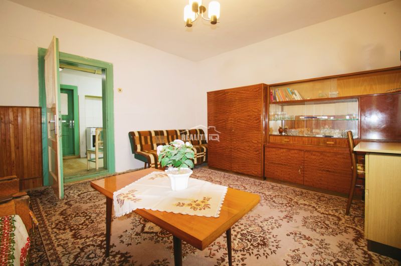 Living room in a family house with wooden furniture and a flower on the table.