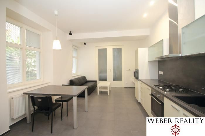 Living room in a two-room apartment with a kitchenette and table, floor with decor.