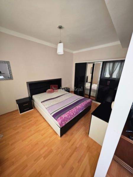 A bedroom with a bed, wardrobe, and wooden decor flooring in a two-room apartment.